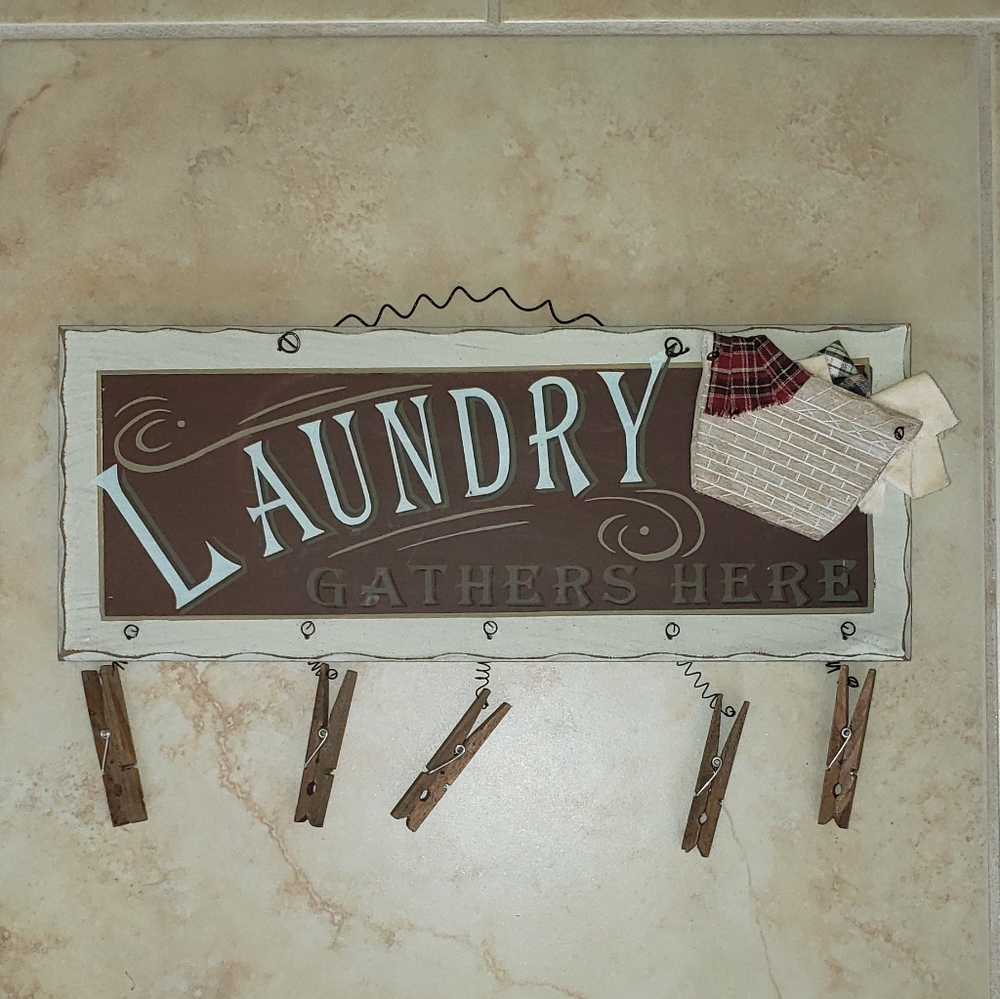 Vintage-look "Laundry gathers here" wooden sign.